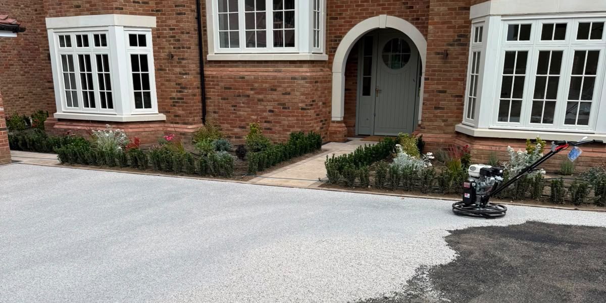 Resin-bound surfacing part laid, with the asphalt base still showing
