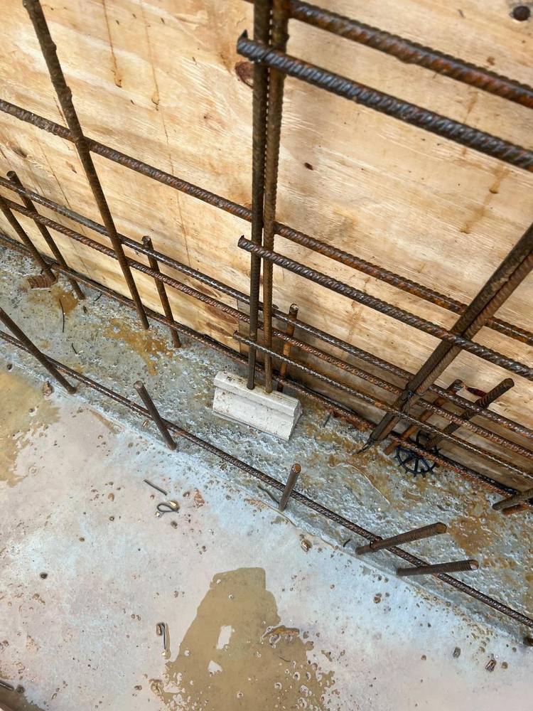 Close view of reinforcement with a concrete spacer holding the cover